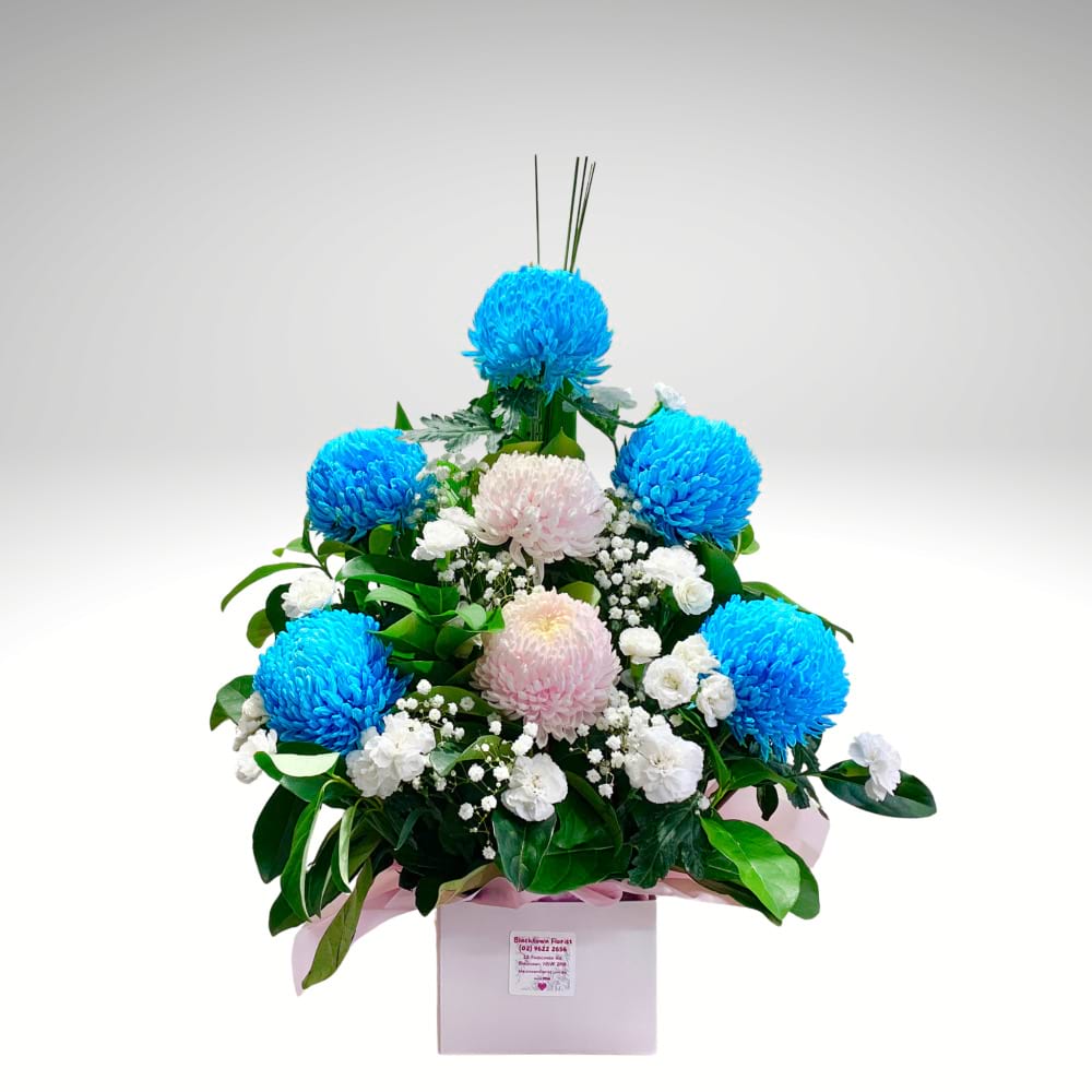 A pastel flower box featuring soft blue and light pink blooms, beautifully arranged in gentle harmony, symbolizing love, calm, and family warmth.